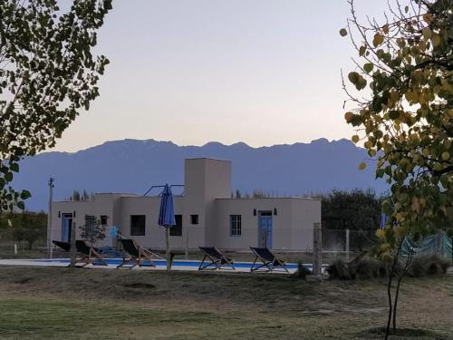 a house with a pool and chairs in front of it at Finca La Clementina in Tunuyán