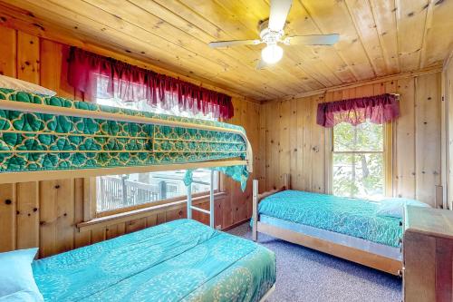 a bedroom with two beds and a ceiling fan at The Cabin on the Lake in Worley