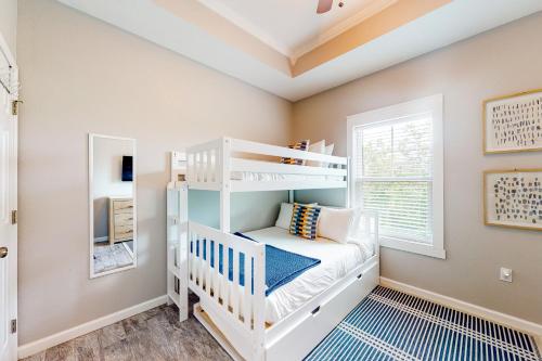 Letto a castello bianco in una camera con finestra di The Emerald Cottage a Mexico Beach