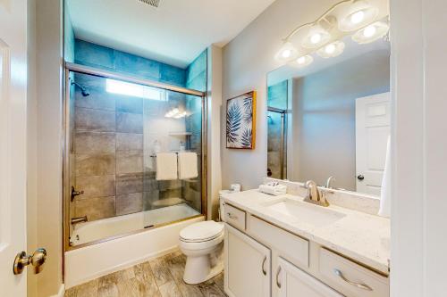 La salle de bains est pourvue de toilettes, d'une douche et d'un lavabo. dans l'établissement The Emerald Cottage, à Mexico Beach