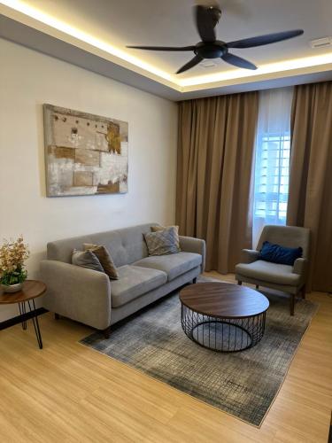 a living room with a couch and a table at Modern Stylish Apartment (Seaview) near KTCC Mall. in Kuala Terengganu