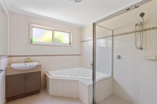a bathroom with a tub and a sink and a shower at 45 Norman Drive in Cowes