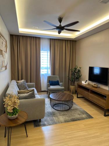 a living room with a couch and a flat screen tv at Modern Stylish Apartment (Seaview) near KTCC Mall. in Kuala Terengganu