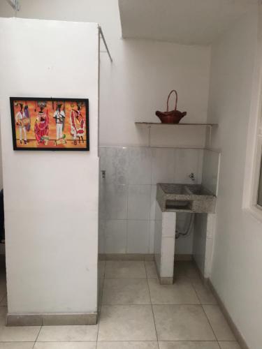 a bathroom with a sink and a painting on the wall at Dorado Airport rooms & apartments in Bogotá