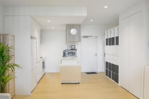 a kitchen with white walls and a kitchen island with a microwave at Rest Modern One Bedroom One Study Apt in Melbourne