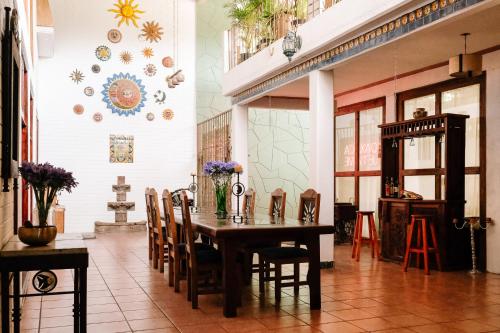 a dining room with a wooden table and chairs at Sunshine House - Made by artists in Oaxaca City