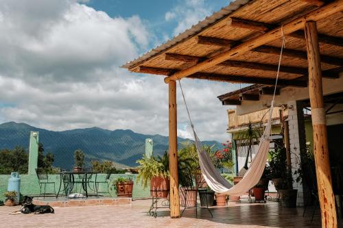 a patio with a hammock and a table and a dog at Sunshine House - Made by artists in Oaxaca City