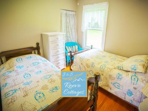 una camera da letto con due letti e un cartello con la scritta "riferimento scambi" di Waterfront Cottage 4 a Riverhead