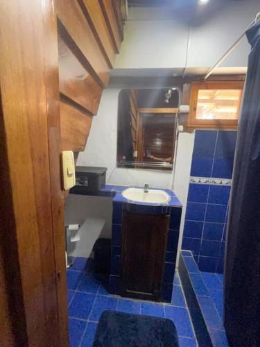 uma casa de banho com um lavatório e piso em azulejo azul em Furnished Apartment in Center of Town em Montañita