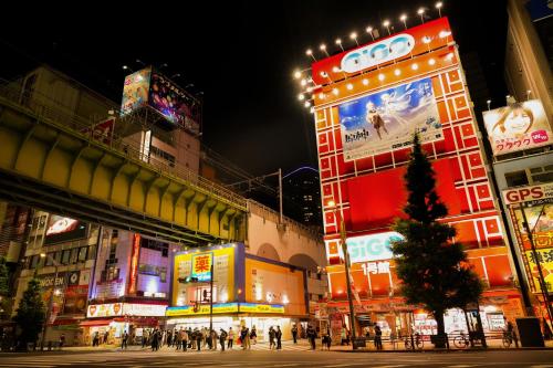 a busy city street at night with people and signs at N Plus Hotel Akihabara in Tokyo