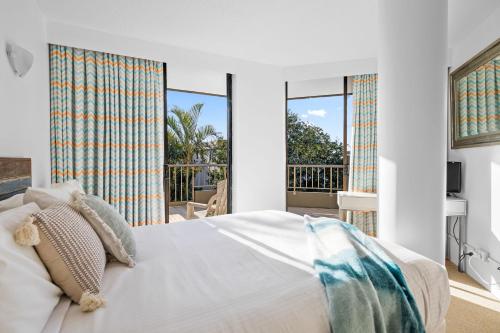 a bedroom with a bed and large windows at The Rocks Resort Unit 2i in Gold Coast