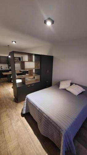 een slaapkamer met een groot bed en een bureau bij Departamento moderno a una cuadra de bv. galvez in Santa Fe