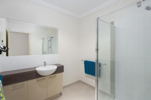 Un baño con lavabo y ducha de cristal. en Beachside Retreat Cowes, en Cowes