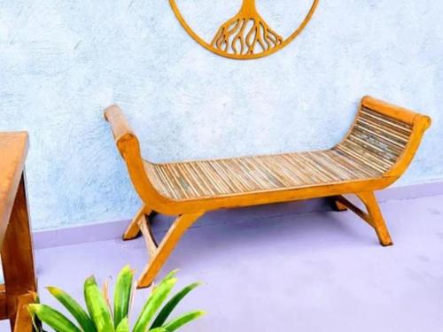 a wooden chair sitting in front of a wall at Pousada Tô na Praia Juquehy in Juquei