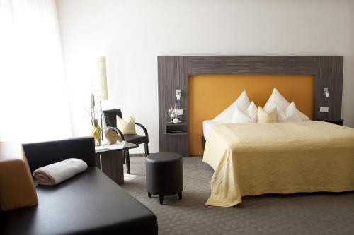 um quarto de hotel com uma cama e um sofá em Hotel Linner em Erding