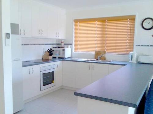 a kitchen with white cabinets and a counter top at Lyall Street Retreat in Ventnor