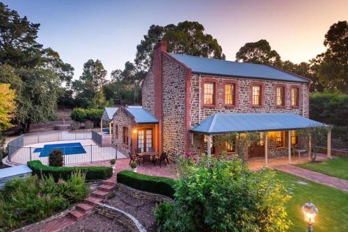 a brick house with a pool and a yard at Hahndorf Luxury Retreat 5 bedrooms for 12 guests in Hahndorf