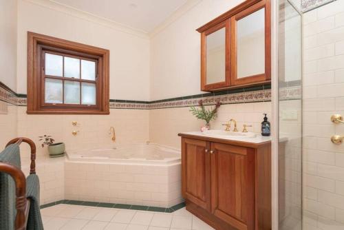 a bathroom with a tub and a sink and a shower at Hahndorf Luxury Retreat in Hahndorf