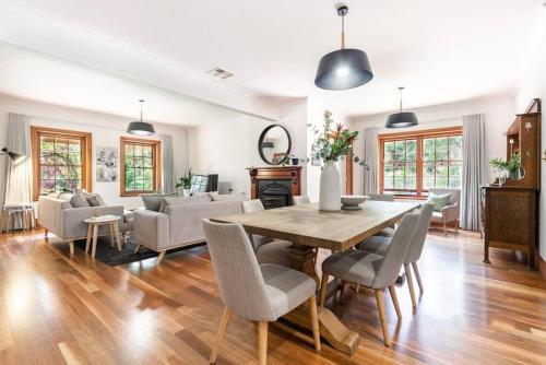 a living room with a wooden table and chairs at Hahndorf Luxury Retreat 5 bedrooms for 12 guests in Hahndorf