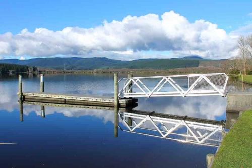 a bridge over a body of water at Black Beauty - Spacious Family Retreat for 12 with Spa in Mangakino