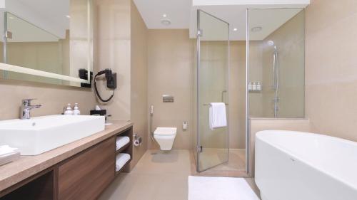 a bathroom with a tub and a sink and a shower at Holiday Inn Gurugram Sector 90 by IHG in Gurgaon