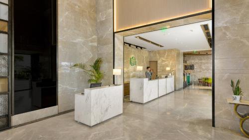 a lobby with a row of white reception desks at Holiday Inn Gurugram Sector 90 by IHG in Gurgaon
