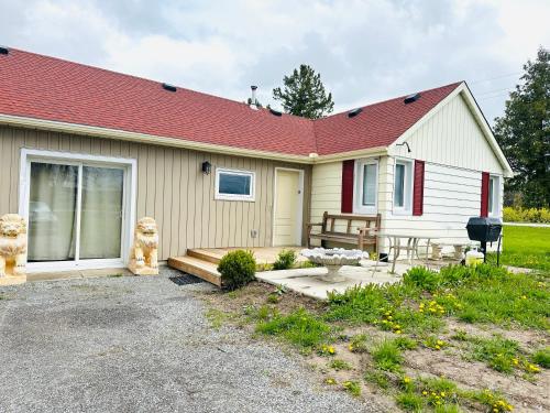 a small house with a porch and a patio at Cozy 3-bedroom farmhouse in wine-country in Niagara on the Lake