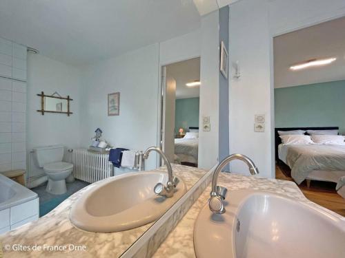 a bathroom with two sinks and a bedroom at Gîte Sarceaux, 4 pièces, 6 personnes - FR-1-497-131 in Sarceaux