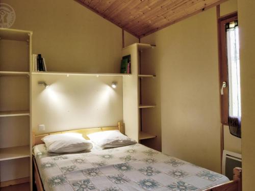 ein Schlafzimmer mit einem Bett mit zwei Kissen darauf in der Unterkunft Gîte Les Noes, 3 pièces, 4 personnes - FR-1-496-245 