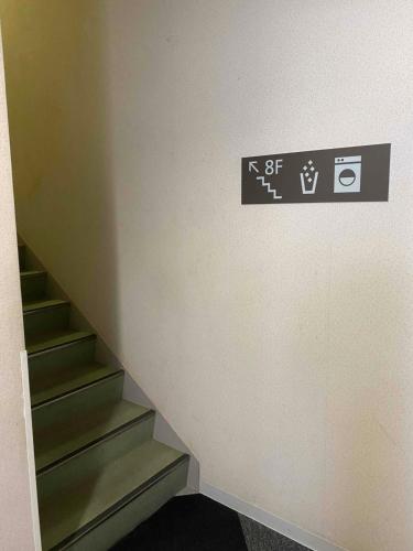 a stairway with a sign on a wall with stairs at Smile Hotel Nagano in Nagano
