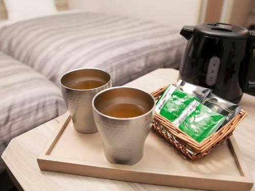 deux tasses de café sur un plateau sur une table dans l'établissement Hotel Route-Inn Kakamigahara, à Kakamigahara