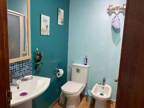 La salle de bains bleue est pourvue de toilettes et d'un lavabo. dans l'établissement Maison du bonheur, à Harhoura