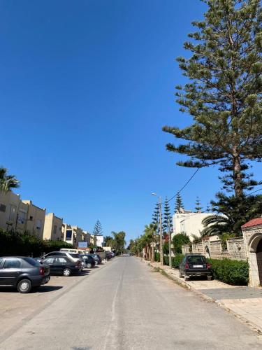 a street with cars parked on the side of the road at Maison du bonheur in El Harhoura