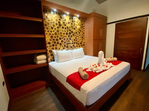 a bedroom with a bed with a red blanket at Termales del Arenal in Fortuna