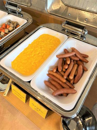 a tray of hot dogs and a dipping sauce at Smile Hotel Nagano in Nagano