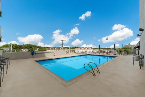 - une piscine avec des chaises et un ciel bleu dans l'établissement Red Roof PLUS & Suites Virginia Beach - Seaside, à Virginia Beach