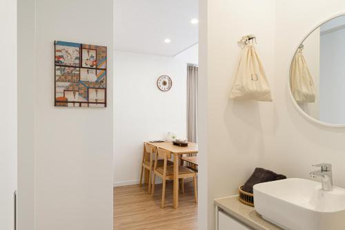 Baño blanco con lavabo y mesa en Urbanstay Boutique Ikseon, en Seúl