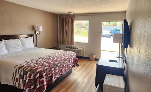 a hotel room with a bed and a window at Red Roof Inn Memphis - Airport in Memphis