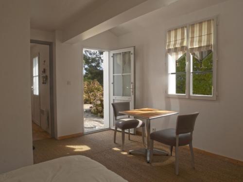 une pièce avec une table et deux chaises et une fenêtre dans l'établissement Villa spacieuse avec jardin clos à 5 min du port de Sauzon, calme absolu, idéale famille, Wi-Fi inclus - FR-1-418-155, à Sauzon