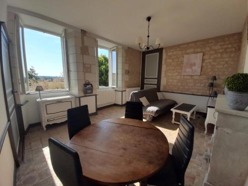 un salon avec une table et des chaises en bois dans l'établissement Gîte au calme avec jardin et WIFI à La Roche-Posay - FR-1-541-52, à La Roche-Posay