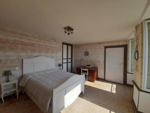 1 dormitorio con cama, escritorio y puerta en Maison La Roche-Posay, 2 pièces, 5 personnes - FR-1-541-52, en La Roche-Posay
