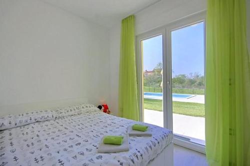 Schlafzimmer mit einem Bett mit grünen Vorhängen und einem Fenster in der Unterkunft Villanova Apartments in Poreč