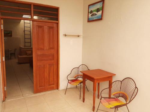 Pokój ze stołem, krzesłami i drzwiami w obiekcie 302 RV Apartments Iquitos-Apartamento familiar con terraza w mieście Iquitos