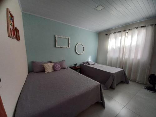 a hotel room with two beds and a window at Chalé Penedo Charmosa in Penedo