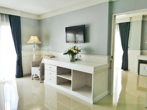 een woonkamer met een wit bureau en een televisie bij ริเวอร์บรีซ เชียงแสน River Breeze Chiangsean in Chiang Saen