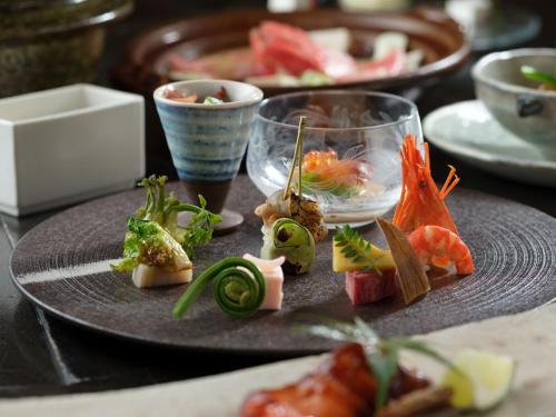 a plate of food on a table with sushi at Akan Tsuruga Besso Hinanoza in Akankohan