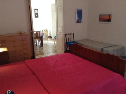 a bedroom with two beds and a red blanket at Favignana Vacanze in Favignana