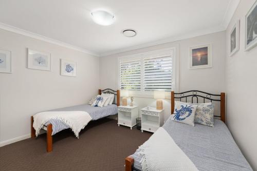 a bedroom with two beds and a window at Government Rd 77 Shoal Bay in Shoal Bay