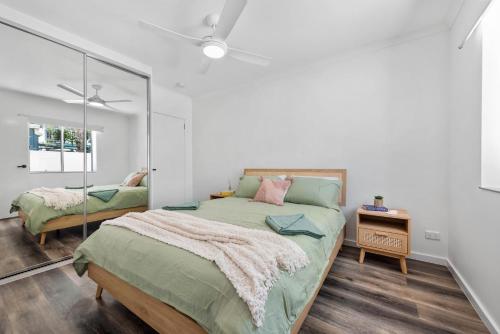 1 dormitorio con 1 cama grande y espejo en Sea Breeze Two Bedroom Apartment en Redcliffe