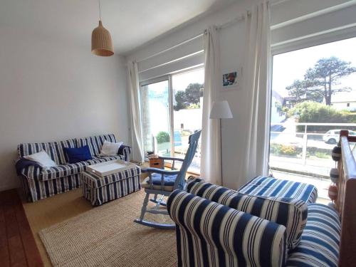 a living room with couches and a large window at Duplex à 50m de la plage avec parking et 2 chambres - FR-1-368-391 in Trégastel
